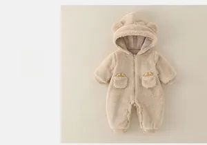 Detail of plush beige baby romper with cute bear ears and soft fleece texture
