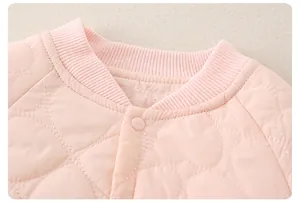 Detail van roze babykatoenen jasje met hartstiksels en geribbelde kraagrand