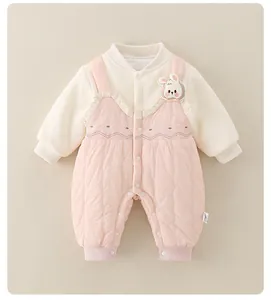 Detail of baby quilted romper with floral embroidery and cute bunny brooch decoration