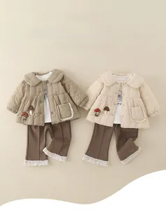 Close-up of quilted winter jacket with mushroom embroidery and lace-trimmed pants
