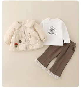 Detail of baby quilted jacket with mushroom patch and lace-edged brown trousers set