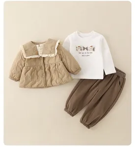 Detailed flat lay of quilted brown jacket with ruffle collar and graphic t-shirt set