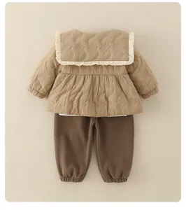 Detail of quilted floral stitching on khaki toddler jacket with ruffled collar and brown pants