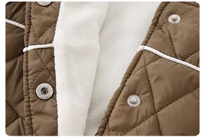 Nahaufnahme der braun gesteppten Babyjacke mit weißem Fleecefutter und Metalldruckknöpfen