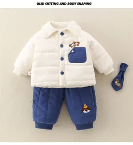 Détail d'un ensemble d'hiver bébé avec veste matelassée et pantalon à broderie chien