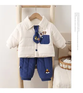 Détail d'un ensemble hiver pour bébé avec broderie chien et accent de cravate bleue