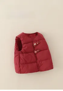 Detail of red quilted baby down vest featuring traditional gourd luck patches