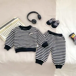 Detailaufnahme des gestreiften Fleece-Sets mit Sweatshirt, Hose und Hunde-Aufnäher