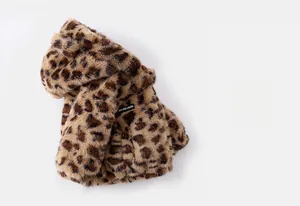 Close-up of soft leopard print faux fur texture and branded woven label for baby coat
