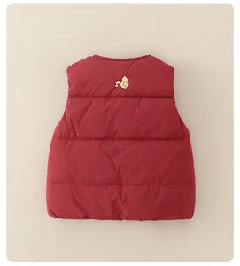 Detail of red quilted down vest for babies with gold embroidery on high-quality fabric