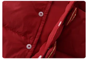 Detail of red quilted down vest with white buttons and yellow stitching accents