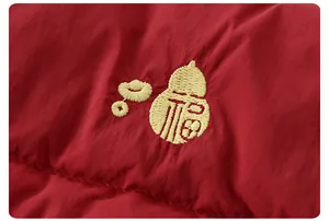Close-up of baby puffer vest featuring yellow gourd and Fu character embroidery
