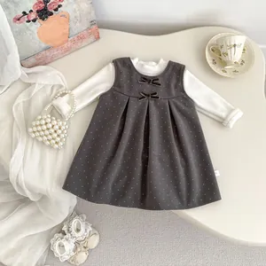 Flat lay of girl's winter set with polka dot bow dress and white turtleneck sweater
