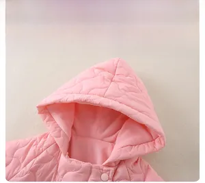 Gros plan d'une barboteuse rose matelassée avec motifs cœurs et doublure douce en peluche