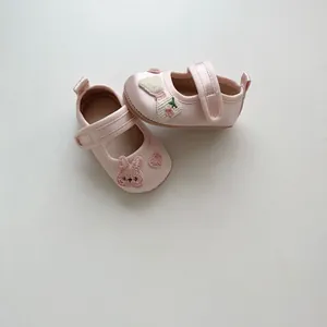 Detailansicht der rosa Baby-Lauflernschuhe aus Satin mit Hasenstickerei und floralen Schleifen