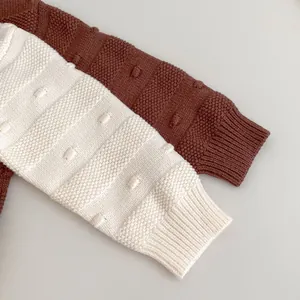 Detailansicht der Rippbündchen und des Strickmusters auf Baby-Mädchenpullovern