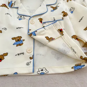 Macro shot of cotton baby pajama top with cute dog print and soft blue piping finish