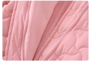 Détail macro d'un manteau matelassé rose pour bébé avec doublure en polaire douce