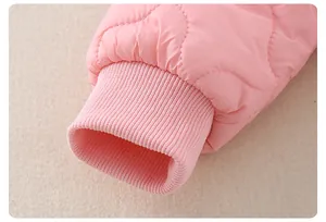Détail du body bébé matelassé rose montrant les coutures et les poignets côtelés