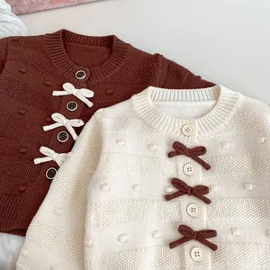Detail der Strickstruktur und Schleifendekoration am Strickcardigan für Kleinkinder