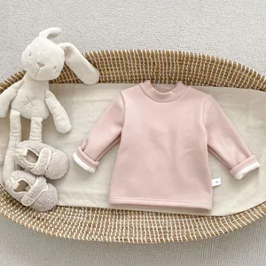 Close-up of pink fleece-lined baby sweatshirt inside a basket with soft plush toy