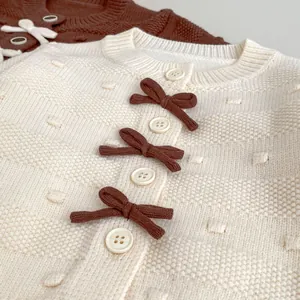 Schicke cremefarbene Strickjacke für Kleinkinder mit braunen Schleifen