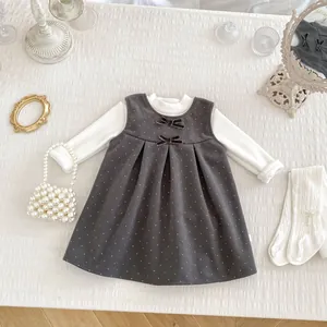 Detail of sweet girls' polka dot dress set with velvet bows and white mock neck top
