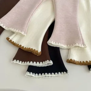 Dettaglio di polsini in maglia a coste colorati con delicati bordi smerlati a onde