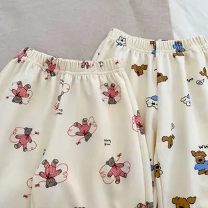 Detail of baby pajama pants featuring cute cartoon bear and puppy prints on soft cotton