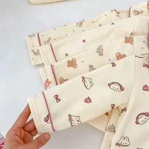 Detalle de puños de algodón suave con ribete rosa y estampados de animales para bebés