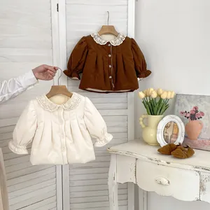 Detailed view of girls' corduroy coats with lace collars in brown and beige colors