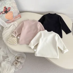 Close-up of children's thermal fleece-lined tops in pink, black and white colors