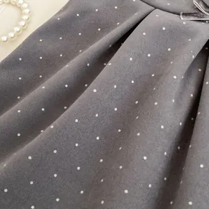 Detail of grey polka dot velvet dress with bow and pearl necklace for vintage style