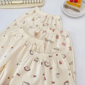 Detalle de cuatro estampados de dibujos en pantalones de pijama para bebés con cintura elástica