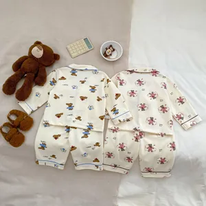 Flat lay of soft cotton baby pajama sets with cute cartoon bear and puppy prints