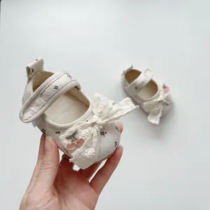 Detail of floral baby girl Mary Jane shoes with lace bow and cherry embroidery
