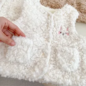 Détail d'un gilet d'hiver en polaire sherpa pour bébé avec broderie de lapin et boutons
