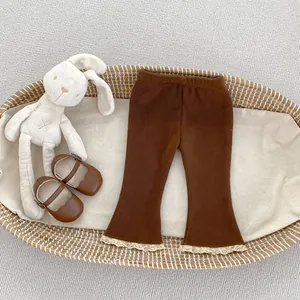 Dettaglio dei pantaloni a zampa in velluto marrone per neonata con bordo in pizzo fine