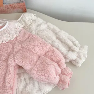 Détail du pyjama polaire bébé montrant le col en dentelle et la texture douce en velours