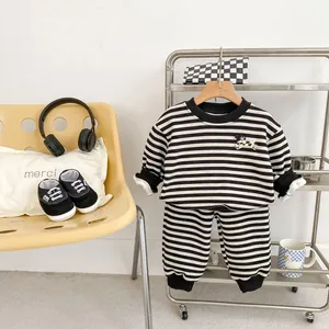 Detailansicht eines gestreiften Baby-Outfits mit Hundeaufnäher und gerippten Bündchen