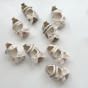 Detail of floral baby walking shoes with lace bows and cherry accents in three colors
