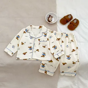 Close-up of baby pajama set with cute dog print and blue piping details on cotton fabric