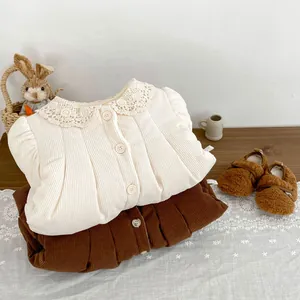 Detail of baby girl corduroy jacket showing delicate lace collar and soft texture