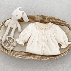 Detailed shot of beige corduroy girl coat with lace collar and ruffled cuffs on flat lay