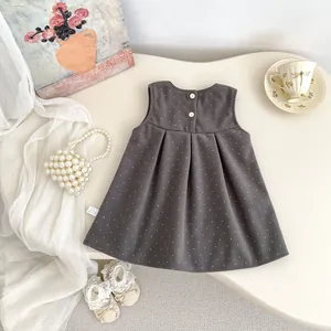 Detailed view of dark grey polka dot dress featuring pleated hem and washing label detail