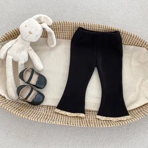 Dettaglio dei pantaloni a zampa neri da bambina con pizzo in un cesto decorativo