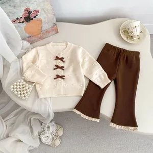 Detail von Baby-Strickjacke mit Schleifen und ausgestellter Ripphose mit Spitzenbesatz