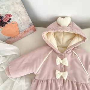 Detail eines rosa Baby-Einteilers mit süßen Schleifen und 3D-Herz an der Kapuze