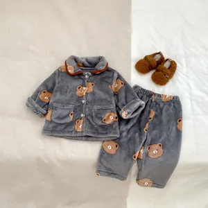 Détail du pyjama bébé en polaire à motif ours avec haut boutonné, pantalon et chaussons