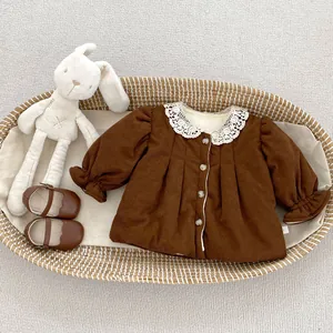 Detail of brown corduroy baby coat featuring a lace collar and elastic ruffles